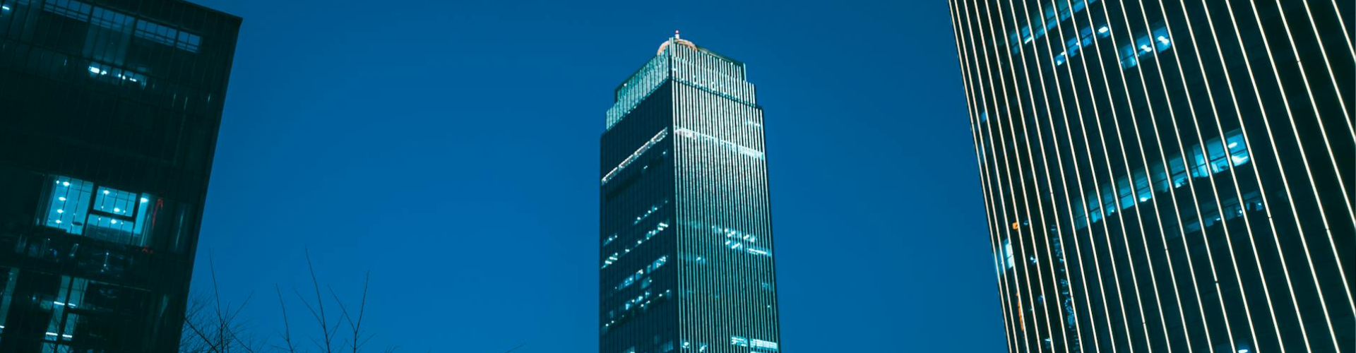 Modern office skyscrapers illuminated at night, representing secure digital infrastructure and enterprise‑level cybersecurity.